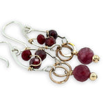 Sterling silver drop earrings with bronze rings holding a ruby faceted sphere, accented with garnet gemstones and red crystal