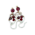 Sterling silver drop earrings with bronze rings holding a ruby faceted sphere, accented with garnet gemstones and red crystal