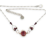 Red striped agate wrapped in hammered bronze wire suspended between sterling silver hammered petals holding faceted garnet and red crystal gemstones on a sterling silver bar chain necklace
