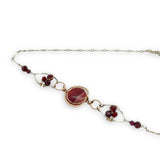Red striped agate wrapped in hammered bronze wire suspended between sterling silver hammered petals holding faceted garnet and red crystal gemstones on a sterling silver bar chain necklace