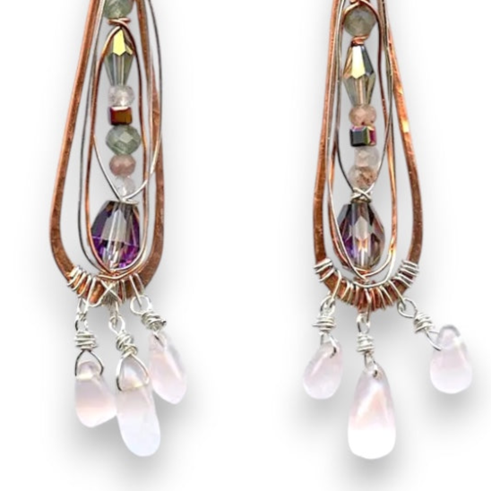 Rose quartz smooth drops dangle from a copper skinny drop earring holding pink crystal, green amethyst, rutilated cherry quartz, and sterling silver wire