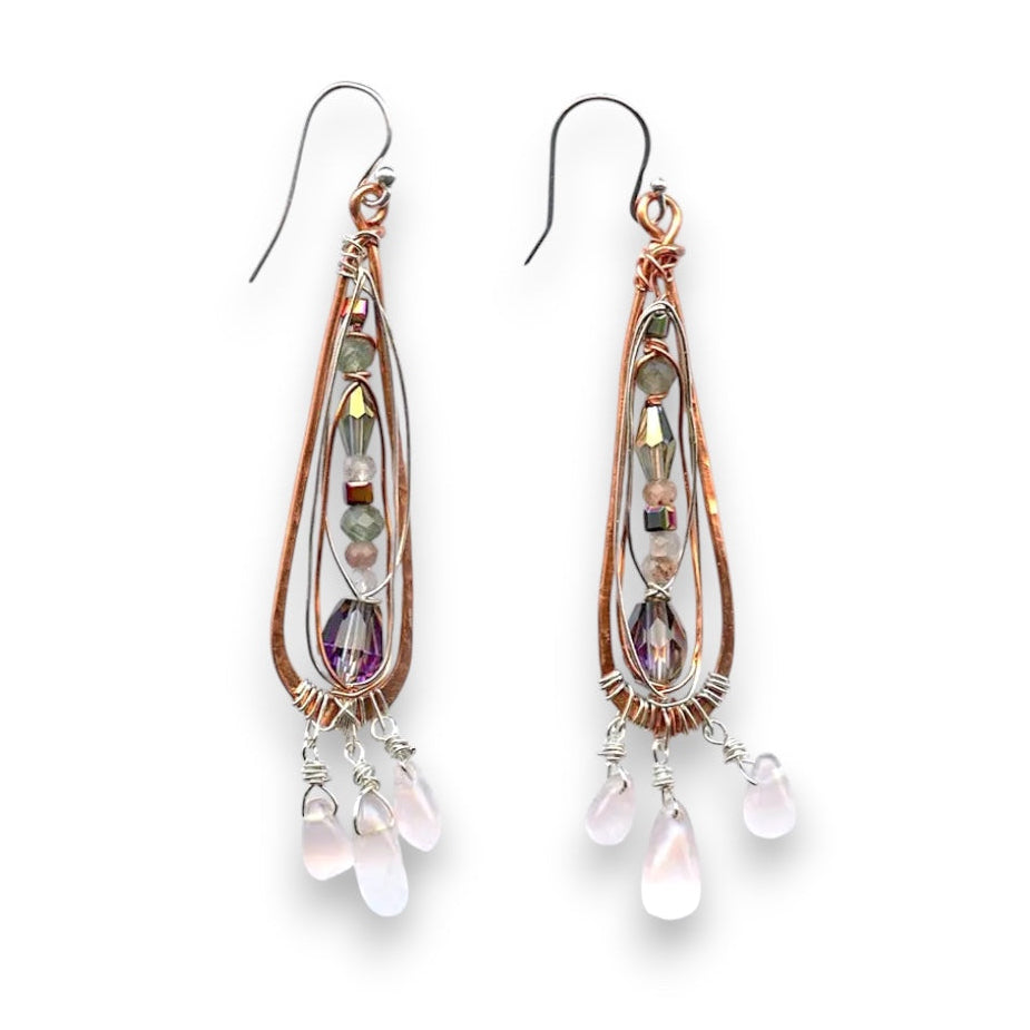 Rose quartz smooth drops dangle from a copper skinny drop earring holding pink crystal, green amethyst, rutilated cherry quartz, and sterling silver wire