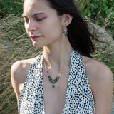 A necklace with blue tourmaline faceted ombre gemstones and silver crystal cubes, featuring a moss agate drop, hammered brass rectangle links, and a handmade hammered brass strap on sterling silver chain