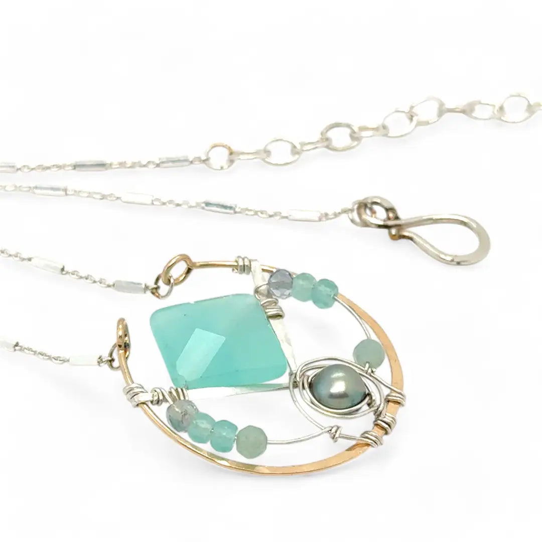 Bronze circle pendant necklace with hammered sterling silver inside holding a chalcedony mint colored diamond, accented with blue silver fresh water pearl and fluorite gemstones on delicate sterling silver chain