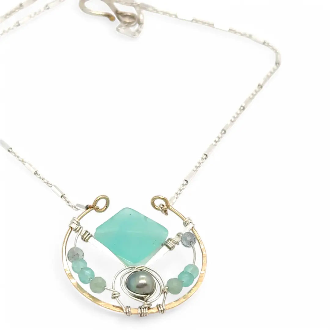 Bronze circle pendant necklace with hammered sterling silver inside holding a chalcedony mint colored diamond, accented with blue silver fresh water pearl and fluorite gemstones on delicate sterling silver chain