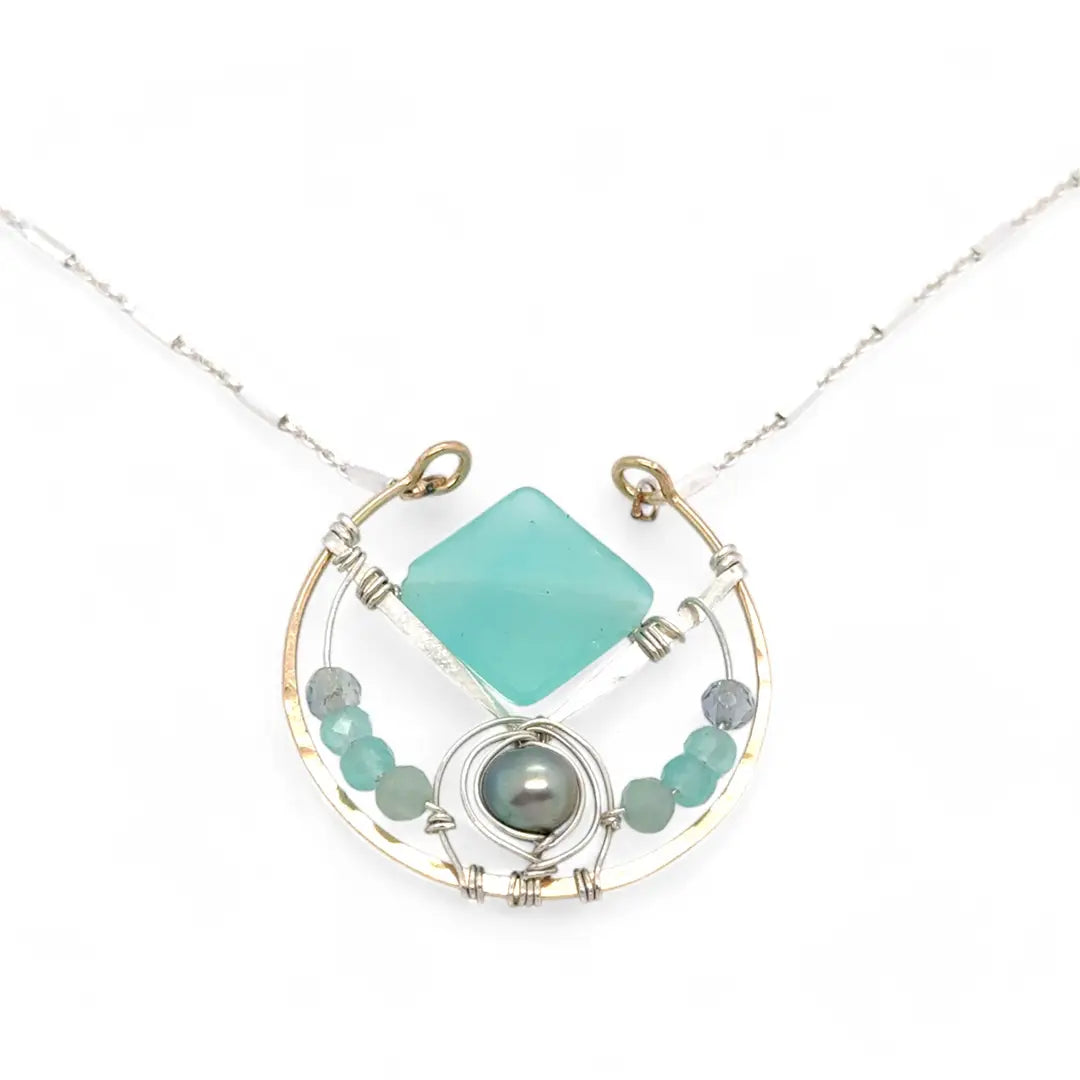 Bronze circle pendant necklace with hammered sterling silver inside holding a chalcedony mint colored diamond, accented with blue silver fresh water pearl and fluorite gemstones on delicate sterling silver chain
