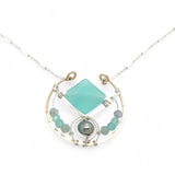 Bronze circle pendant necklace with hammered sterling silver inside holding a chalcedony mint colored diamond, accented with blue silver fresh water pearl and fluorite gemstones on delicate sterling silver chain