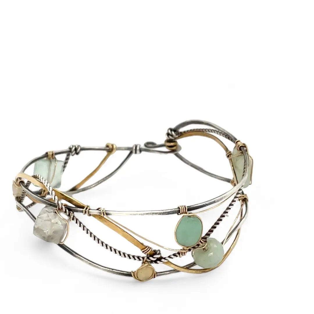 Oxidized sterling silver and brass hammered waves form a lovely cuff bracelet adorned with prehnite, jade, opal, and green amethyst gemstones on gold filled wire