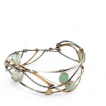 Oxidized sterling silver and brass hammered waves form a lovely cuff bracelet adorned with prehnite, jade, opal, and green amethyst gemstones on gold filled wire