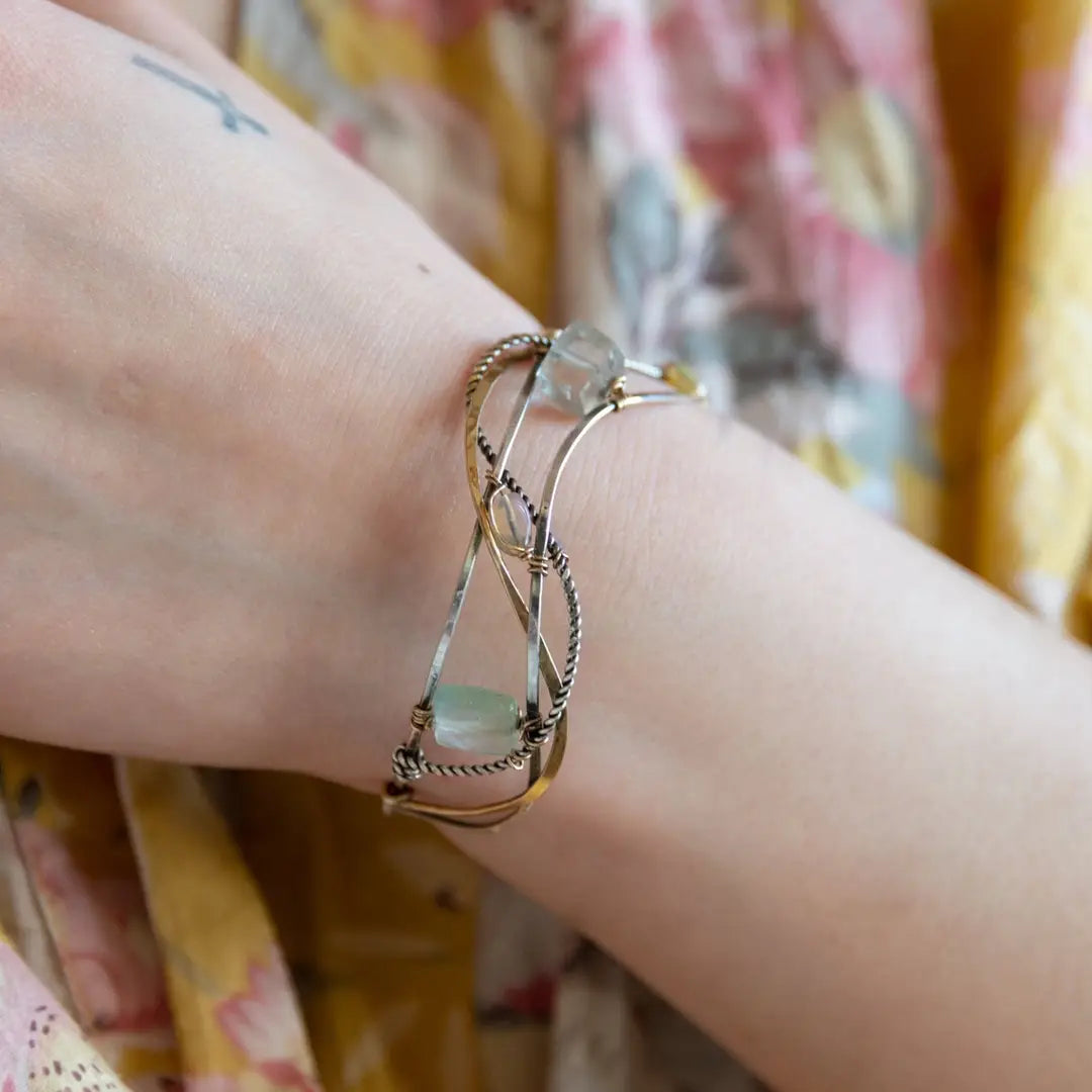 Oxidized sterling silver and brass hammered waves form a lovely cuff bracelet adorned with prehnite, jade, opal, and green amethyst gemstones on gold filled wire