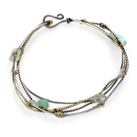 Oxidized sterling silver and brass hammered waves form a lovely cuff bracelet adorned with prehnite, jade, opal, and green amethyst gemstones on gold filled wire