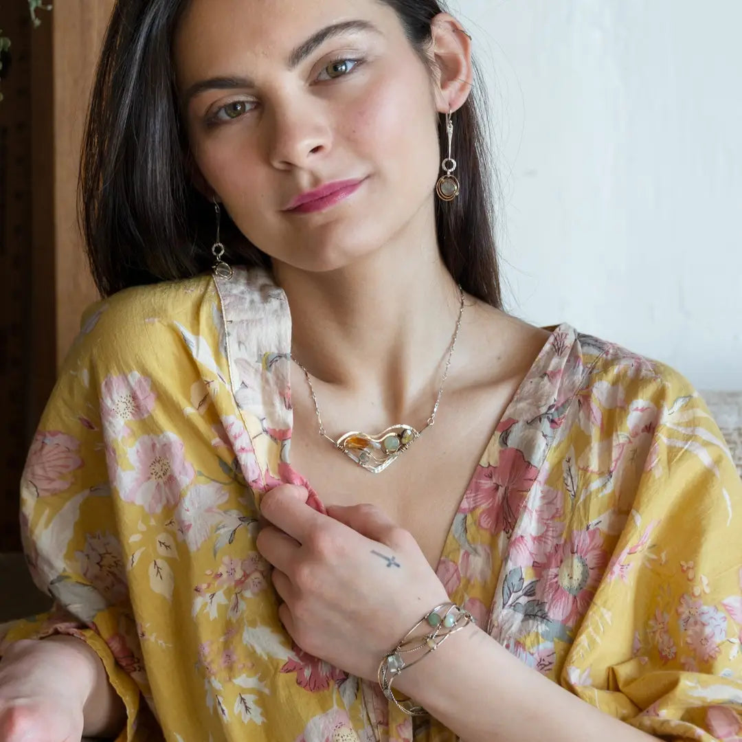 Oxidized sterling silver and brass hammered waves form a lovely cuff bracelet adorned with prehnite, jade, opal, and green amethyst gemstones on gold filled wire
