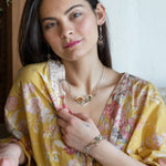 Oxidized sterling silver and brass hammered waves form a lovely cuff bracelet adorned with prehnite, jade, opal, and green amethyst gemstones on gold filled wire