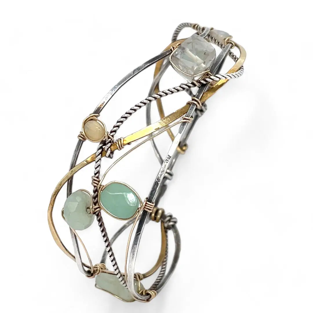 Oxidized sterling silver and brass hammered waves form a lovely cuff bracelet adorned with prehnite, jade, opal, and green amethyst gemstones on gold filled wire