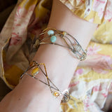 Oxidized sterling silver and brass hammered waves form a lovely cuff bracelet adorned with prehnite, jade, opal, and green amethyst gemstones on gold filled wire