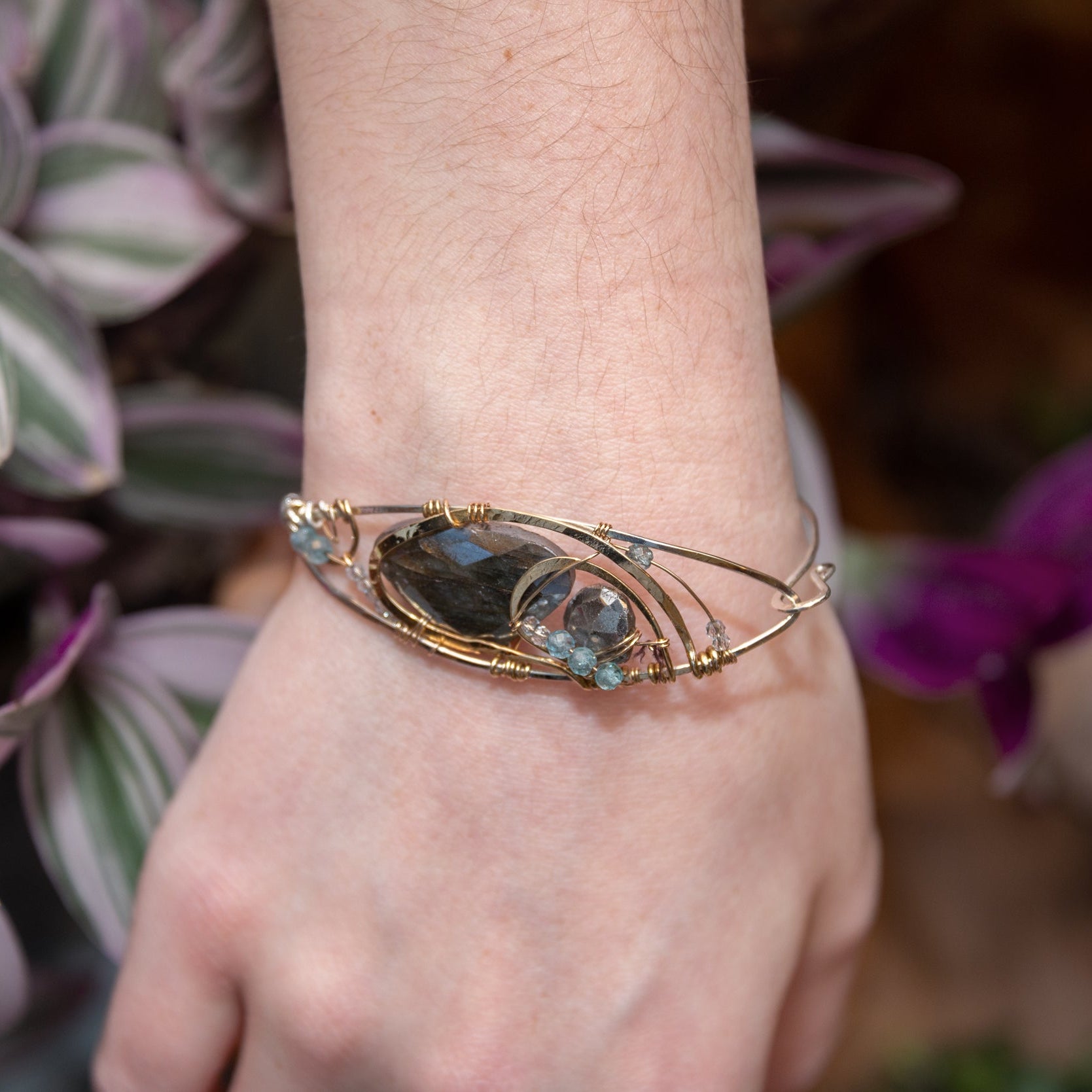 Flashy labradorite, pyrite, and apatite gemstones share space within a sterling silver and brass cuff bracelet with gold filled wire
