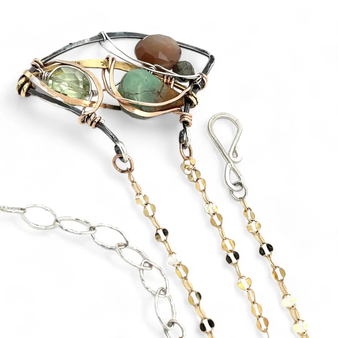 A dark sterling silver pendant necklace with gold-filled chain, featuring a turquoise drop, faceted green amethyst coin, and a golden sheen faceted moonstone in bronze wire