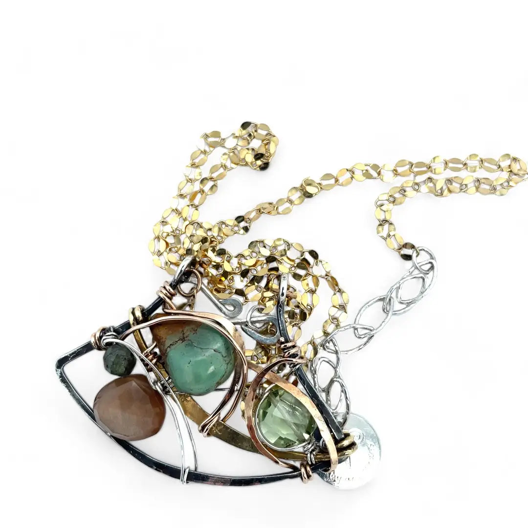 A dark sterling silver pendant necklace with gold-filled chain, featuring a turquoise drop, faceted green amethyst coin, and a golden sheen faceted moonstone in bronze wire