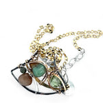 A dark sterling silver pendant necklace with gold-filled chain, featuring a turquoise drop, faceted green amethyst coin, and a golden sheen faceted moonstone in bronze wire