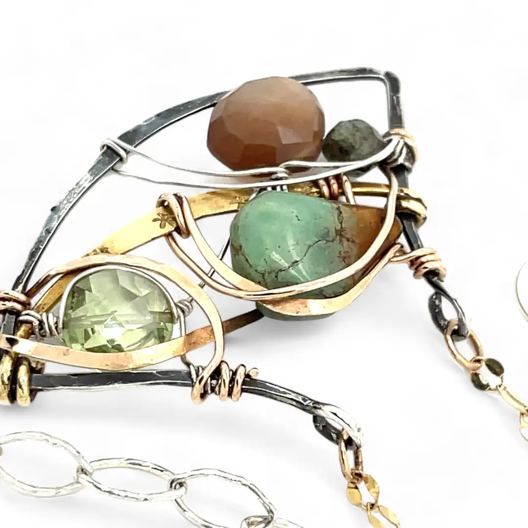 A dark sterling silver pendant necklace with gold-filled chain, featuring a turquoise drop, faceted green amethyst coin, and a golden sheen faceted moonstone in bronze wire