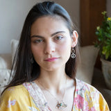 A dark sterling silver pendant necklace with gold-filled chain, featuring a turquoise drop, faceted green amethyst coin, and a golden sheen faceted moonstone in bronze wire