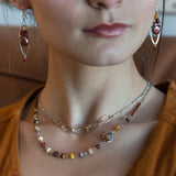 An adjustable sterling silver necklace with a bar chain design and a signature clasp, featuring textured and hammered sterling silver and bronze oval links.