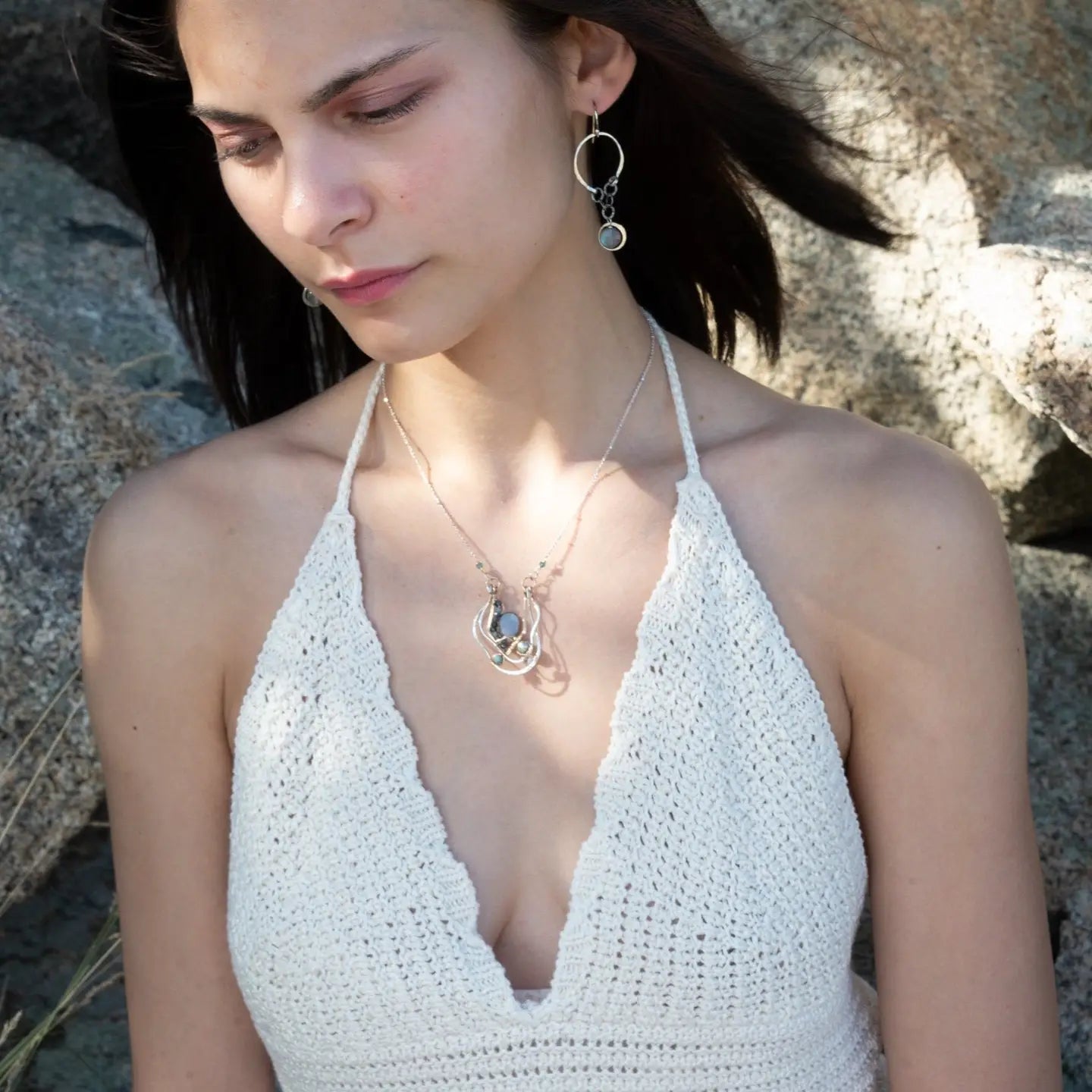 A pair of sterling silver hoop earrings with labradorite faceted coins inside mini sterling silver hammered rings, suspended from oxidized crinkle chain.