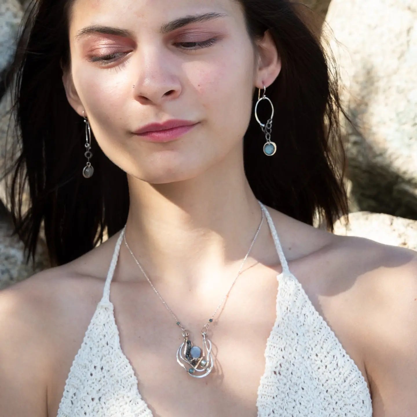 A pair of sterling silver hoop earrings with labradorite faceted coins inside mini sterling silver hammered rings, suspended from oxidized crinkle chain.