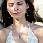 A pair of sterling silver hoop earrings with labradorite faceted coins inside mini sterling silver hammered rings, suspended from oxidized crinkle chain.