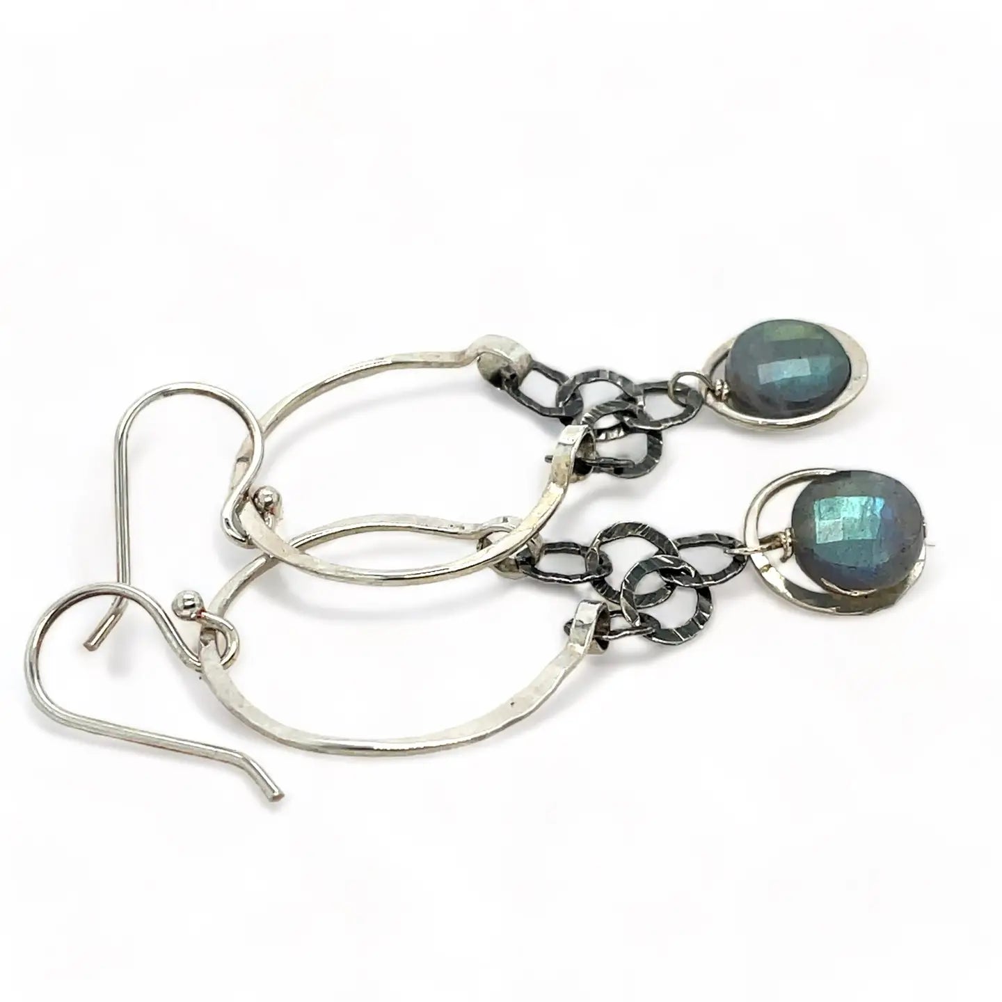 A pair of sterling silver hoop earrings with labradorite faceted coins inside mini sterling silver hammered rings, suspended from oxidized crinkle chain.