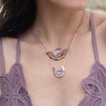 A sterling silver hammered necklace with gold-filled accents, featuring a faceted amethyst gemstone pendant and an adjustable chain with a handmade signature clasp.
