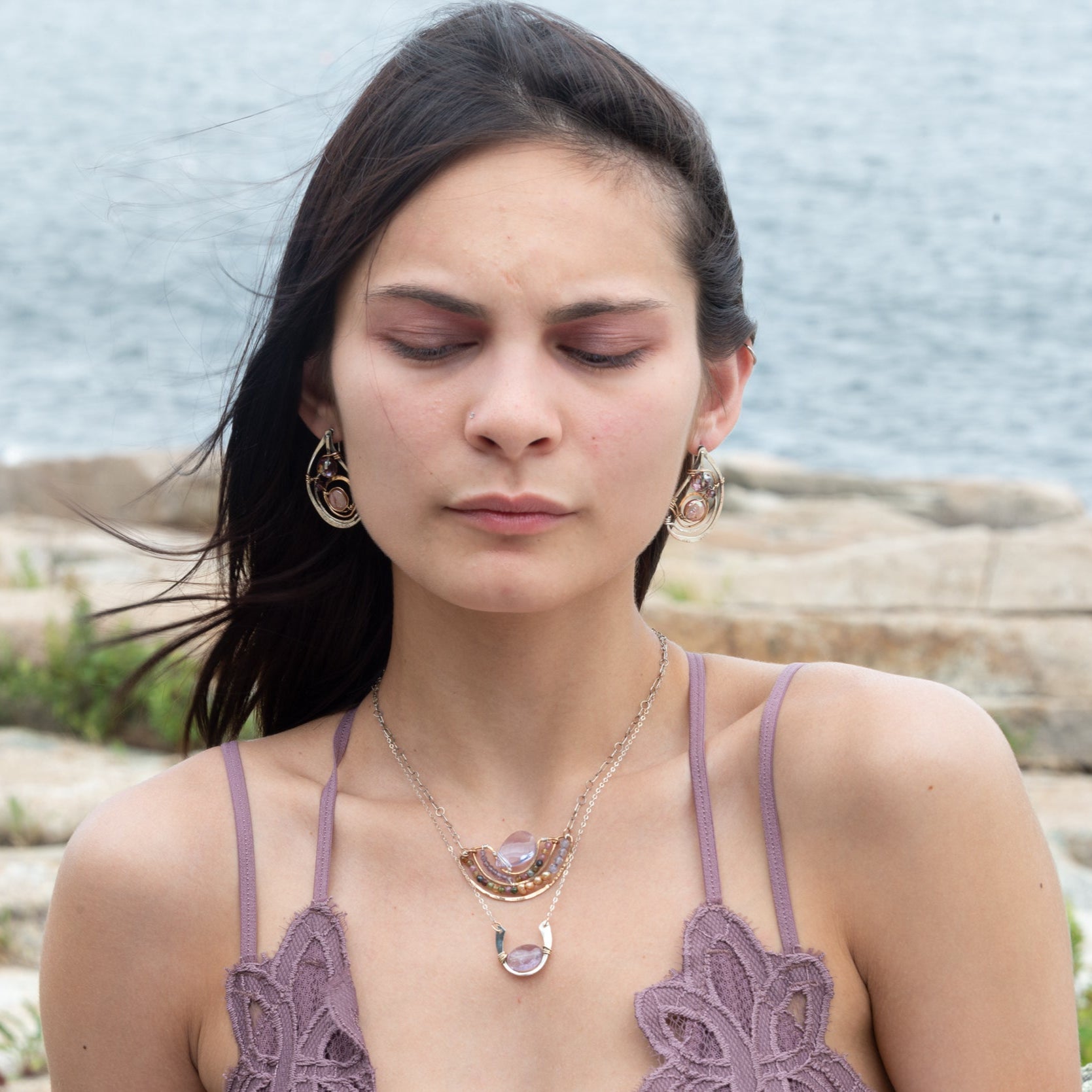 A sterling silver hammered necklace with gold-filled accents, featuring a faceted amethyst gemstone pendant and an adjustable chain with a handmade signature clasp.