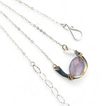 A sterling silver hammered necklace with gold-filled accents, featuring a faceted amethyst gemstone pendant and an adjustable chain with a handmade signature clasp.