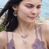 A sterling silver hammered necklace with gold-filled accents, featuring a faceted amethyst gemstone pendant and an adjustable chain with a handmade signature clasp.