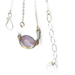 A sterling silver hammered necklace with gold-filled accents, featuring a faceted amethyst gemstone pendant and an adjustable chain with a handmade signature clasp.