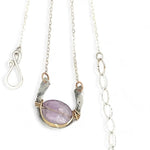 A sterling silver hammered necklace with gold-filled accents, featuring a faceted amethyst gemstone pendant and an adjustable chain with a handmade signature clasp.