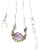 A sterling silver hammered necklace with gold-filled accents, featuring a faceted amethyst gemstone pendant and an adjustable chain with a handmade signature clasp.