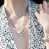 A sterling silver necklace with a pendant featuring fresh water pearl, moonstone, and pyrite gemstones, complemented by an oxidized sterling silver satellite chain.