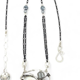 A sterling silver necklace with a pendant featuring fresh water pearl, moonstone, and pyrite gemstones, complemented by an oxidized sterling silver satellite chain.