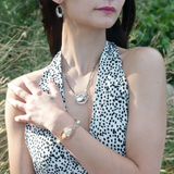 A sterling silver necklace with a pendant featuring fresh water pearl, moonstone, and pyrite gemstones, complemented by an oxidized sterling silver satellite chain.