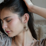 A pair of handcrafted sterling silver drop earrings with swirling bronze curls, featuring smokey quartz gemstones and freshwater pearls and pyrite