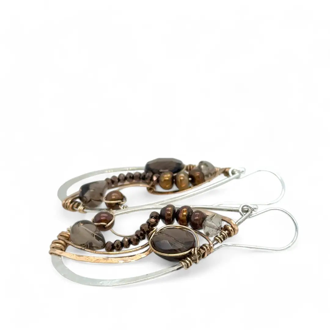 A pair of handcrafted sterling silver drop earrings with swirling bronze curls, featuring smokey quartz gemstones and freshwater pearls and pyrite