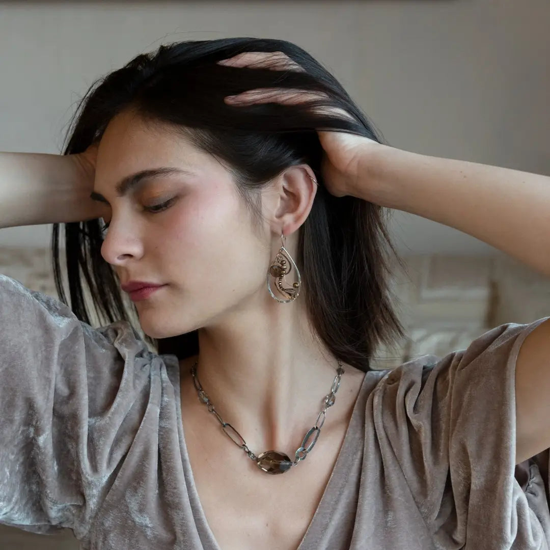A pair of handcrafted sterling silver drop earrings with swirling bronze curls, featuring smokey quartz gemstones and freshwater pearls and pyrite