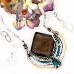 Handmade brass pendant necklace with smoky quartz faceted tile gemstone, embellished with smaller faceted pyrite, apatite, and chrysocolla, showcased with an oval silver chain and clasp