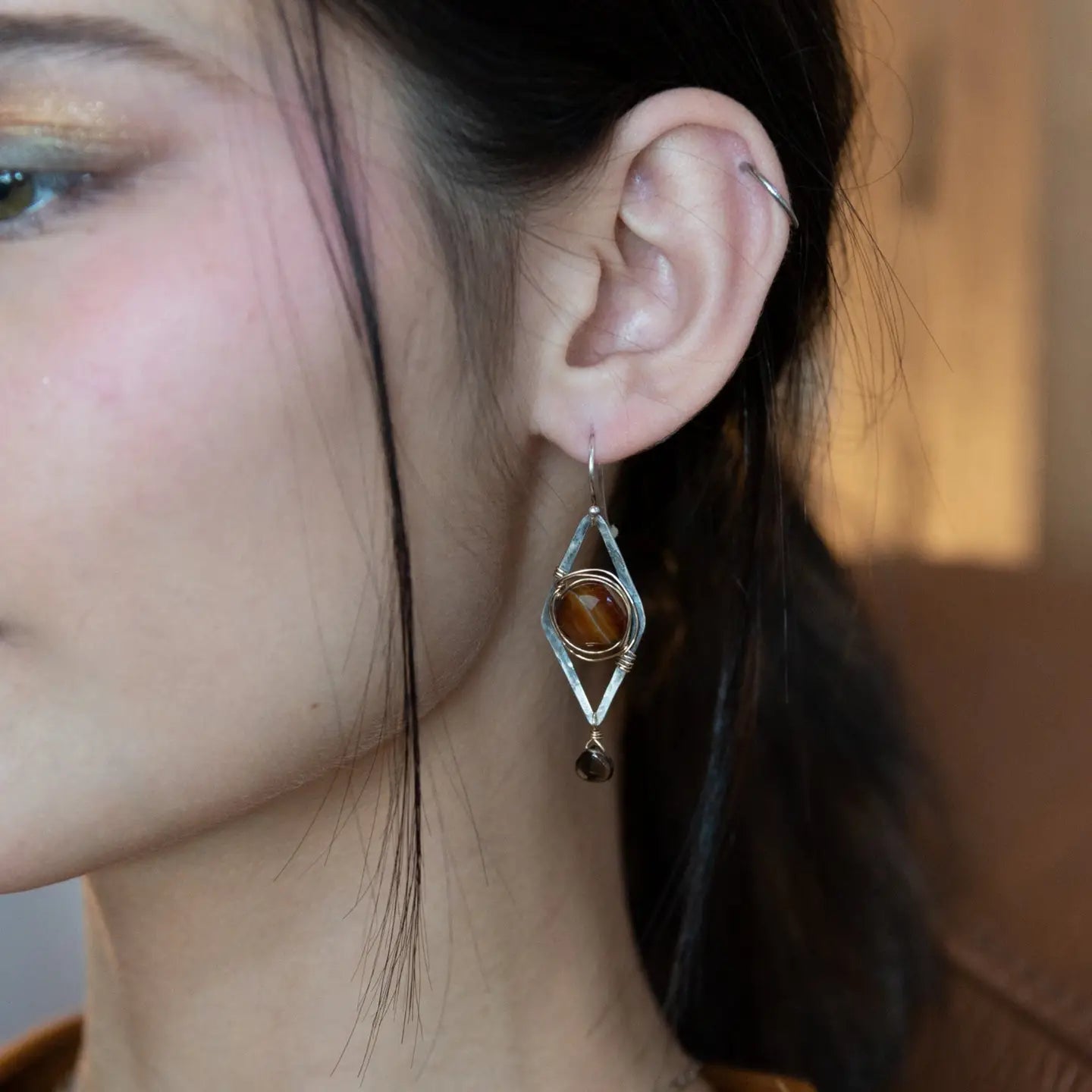 Rust colored striped agate coin gemstones are triple wrapped in gold filled wire on oxidized sterling silver diamond earrings with a smokey quartz smooth teardrop dangle