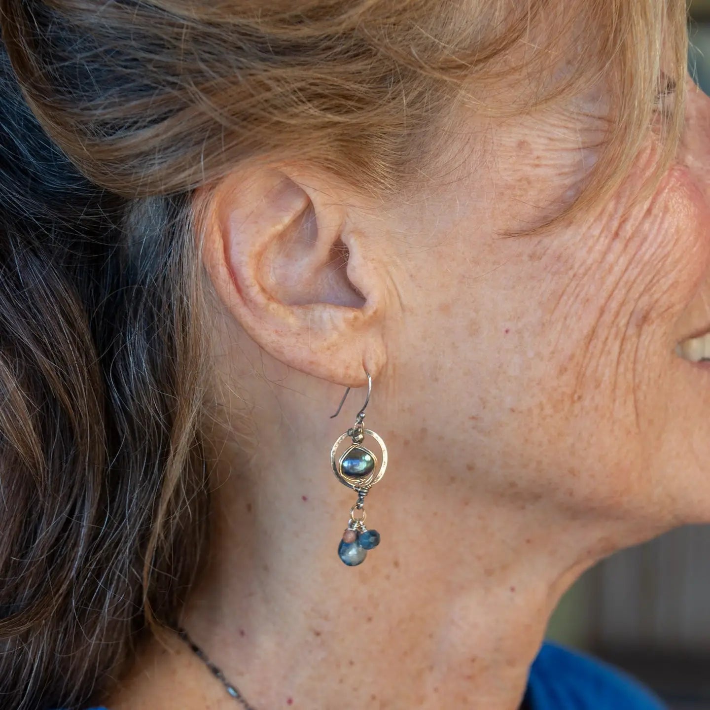 Darkened sterling silver mini circle earrings with fresh water peacock pealrs wrapped in gold filled wire, featuring sapphire, aquamarine, and sunstone dangles