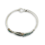 Apatite and chrysocolla gemstones surround a labradorite marquise gemstones held in gold filled and oxidized sterling silver twist wire inside a sterling silver handmade cuff bracelet