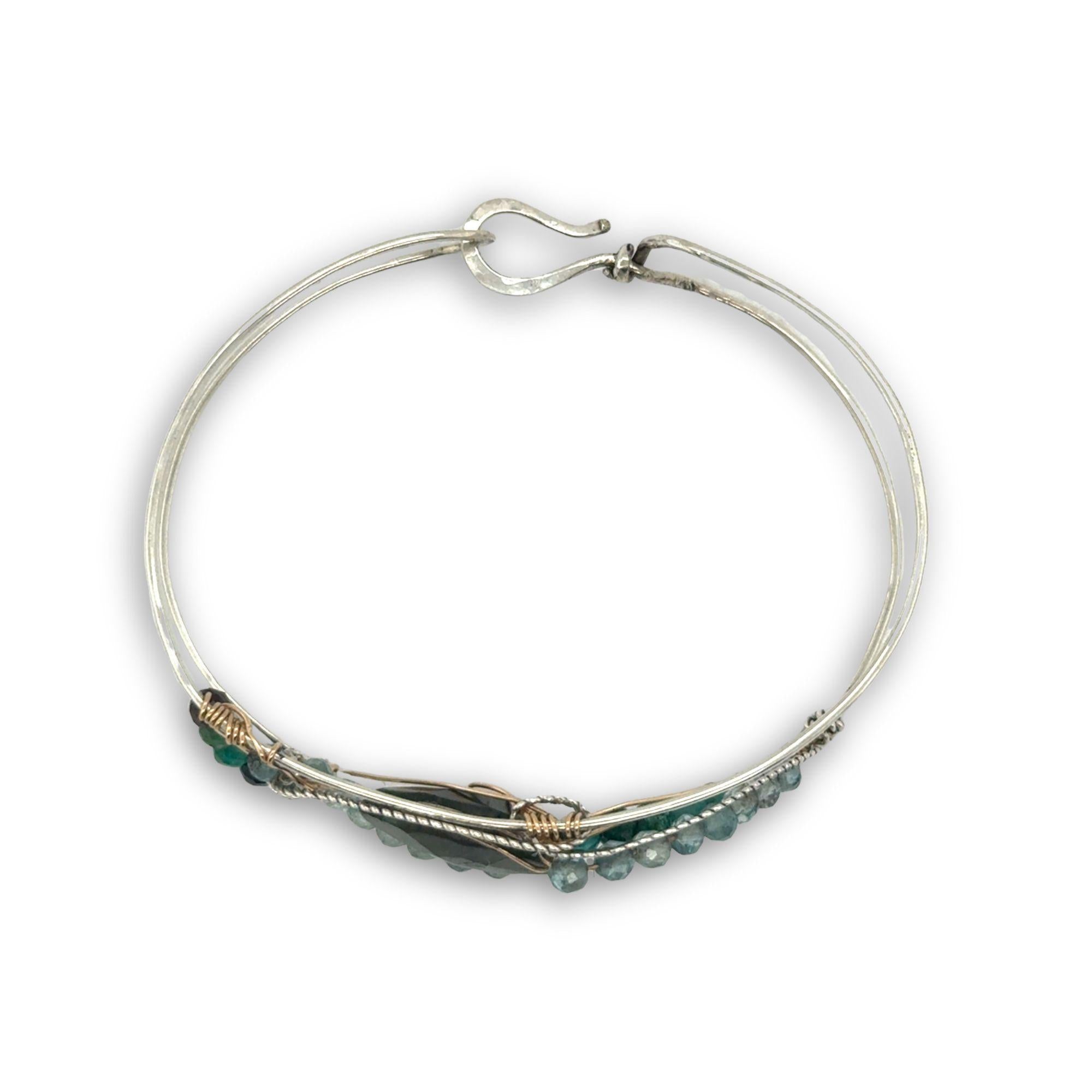 Apatite and chrysocolla gemstones surround a labradorite marquise gemstones held in gold filled and oxidized sterling silver twist wire inside a sterling silver handmade cuff bracelet