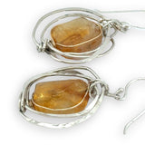 Sterling silver hammered knot earrings holding citrine nugget gemstones