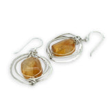 Sterling silver hammered knot earrings holding citrine nugget gemstones